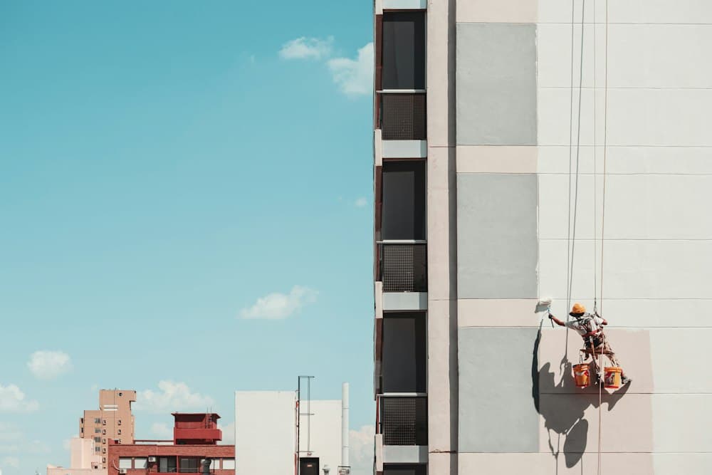 Technician painting the exterior wall of a commercial building