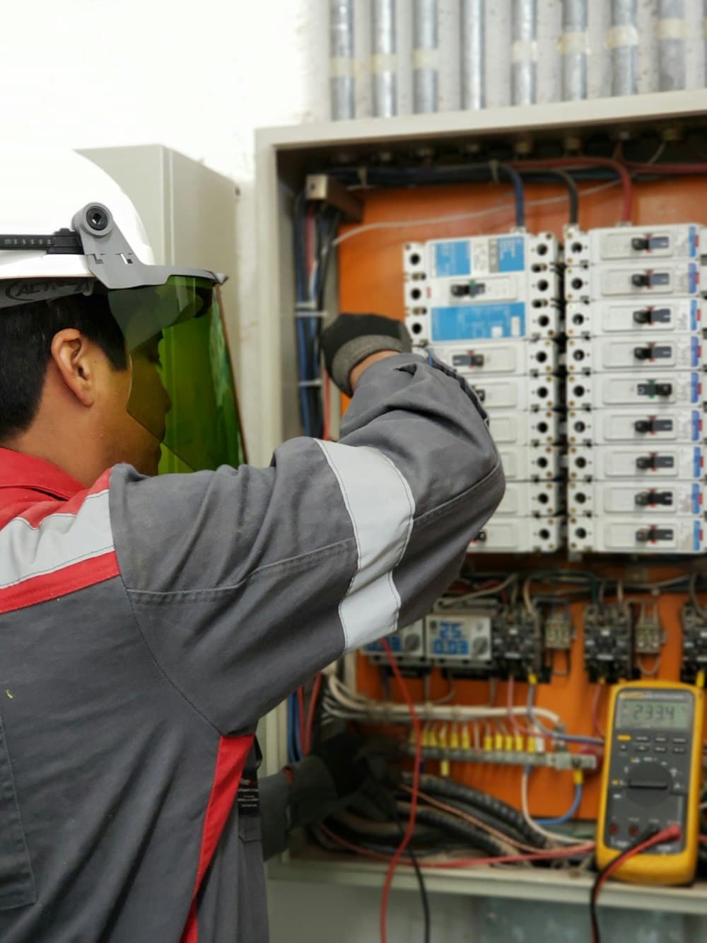 Technician inspecting and testing an electrical panel